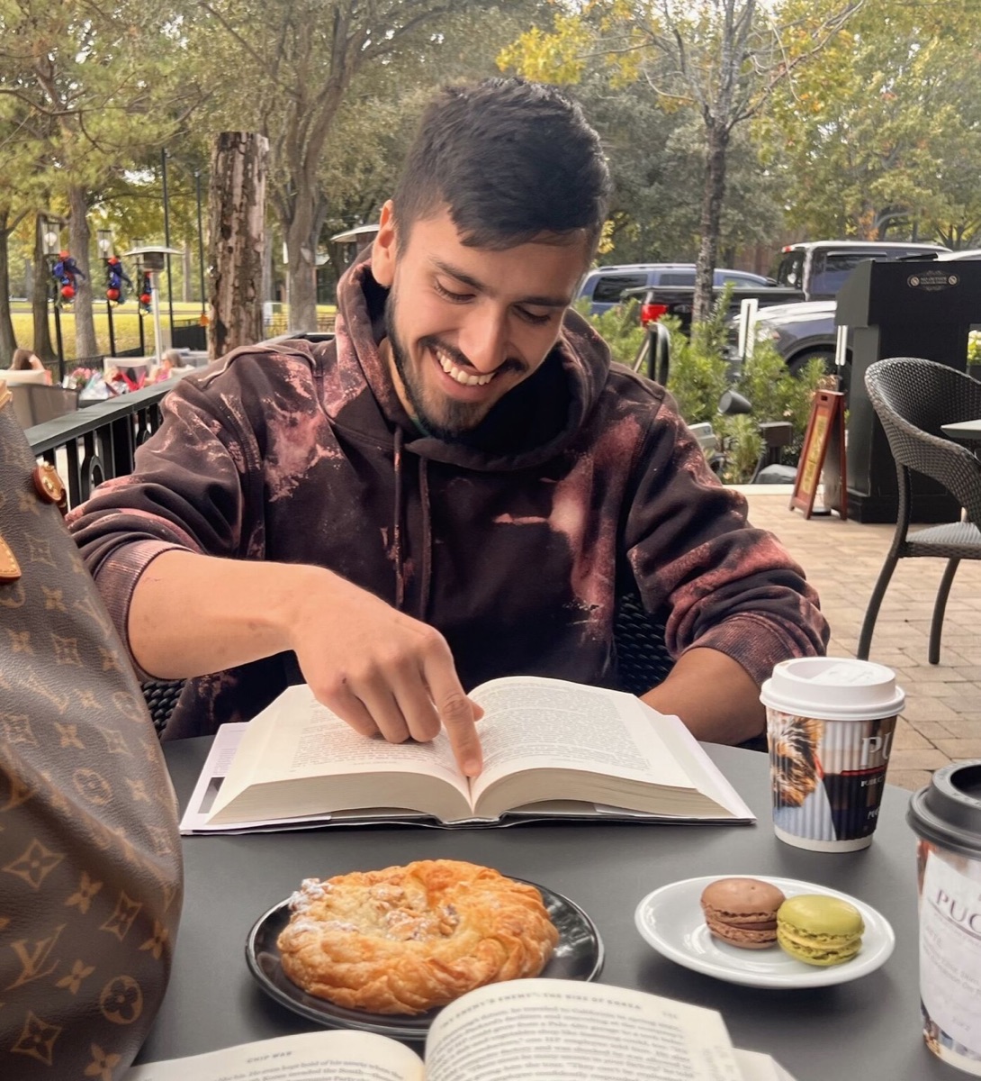 Sam reading at a cafe table